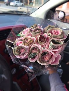 a bunch of money wrapped in plastic sitting on the dashboard of a car