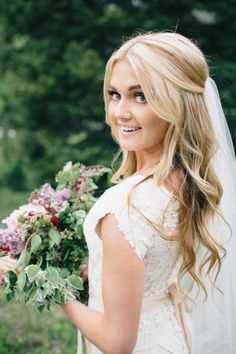 a beautiful blonde bride holding a bouquet of flowers