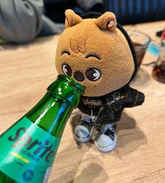 a stuffed animal is drinking from a beer bottle