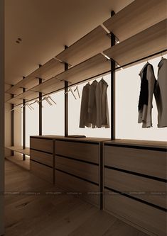 an empty clothing store with clothes hanging in the window and wooden flooring on display