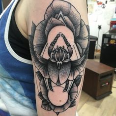 a woman's arm with a tattoo on it that has an image of a flower in the center