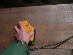 a person using a power tool on a wooden surface