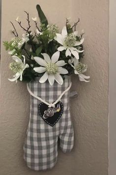 a teddy bear with flowers in it hanging on the wall