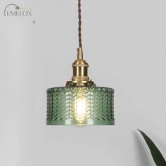 Introducing the Isabella Retro Short Cylinder Pendant Lighting, the perfect addition to your retro-inspired interior. Featuring a clear and green wavy glass shade, this ceiling hang lamp exudes a unique charm that instantly catches the eye. The brass finish adds a touch of elegance and blends seamlessly with any decor style. With its single head design, it provides ample illumination to brighten up your space. The rotary switch allows for easy control, giving you the flexibility to adjust the lighting to suit your mood and needs. Whether used as a focal point in your living room or as a statement piece in your chen, the Isabella Retro Pendant Lighting brings a timeless vintage appeal to your space.Size: 5 to 9 Inch Fixture Width: 6" Fixture Height: 6" Chain/cord Length: 45" Bulb Included: Pendulum Lights, Antique Pendant Light, Cylinder Pendant Light, Glass Pendant Ceiling Light, Glass Ceiling Pendant, Brass Pendant Light, Style Deco, Glass Ceiling, Glass Pendant Light