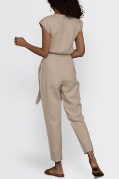 Our Evening Chai Hemp V-Neck Jumpsuit - a chic V-neck ensemble designed for stylish versatility. Featuring micro sleeves and straight-cut legs, this trendy jumpsuit offers a voguish look, perfect from day to night. Crafted with a tapered fit and a concealed placket, this jumpsuit has functional pockets on both sides, adding practicality to its stylish appeal. Elevate your wardrobe with this contemporary piece, ideal for brunch, evening events, or casual outings Wash in cold water or dry clean on Chic Fitted V-neck Pantsuit, Chic Linen Jumpsuits And Rompers With Short Sleeves, Chic Short Sleeve Workwear Pantsuit, Chic Short Sleeve Pantsuit For Work, Casual V-neck Pantsuit For Work, Chic Beige Pantsuit For Summer, Fitted V-neck Pantsuit For Summer, Trendy Jumpsuit, To Night