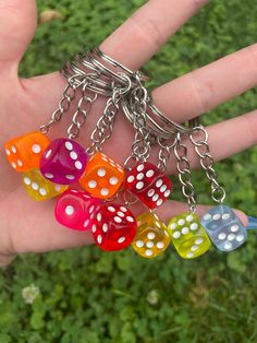 a hand holding several dice shaped key chains