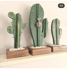 three wooden cactus sculptures on top of a shelf