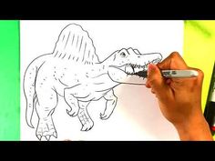 someone is drawing a dinosaur on paper with marker and pen in front of the image