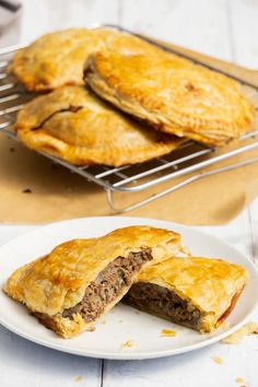 two meat pies on a plate with one cut in half