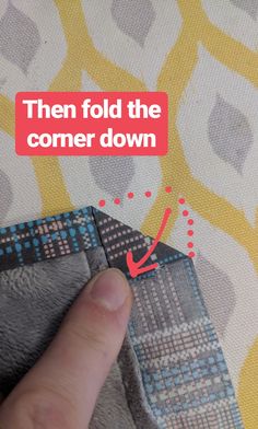 someone is pointing at the corner of a piece of fabric