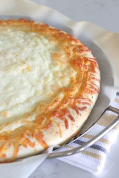 a pizza sitting on top of a white plate next to a fork and napkins