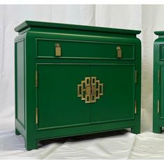 two green sideboards with gold handles on each one and another piece of furniture in the background