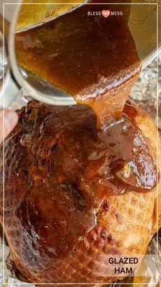 a person pouring gravy on top of a baked ham