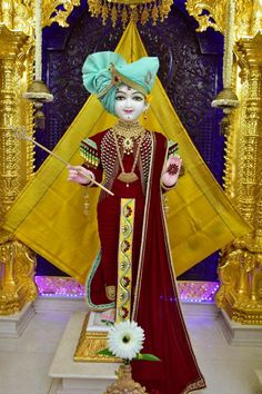 an elaborately dressed woman standing in front of a golden pyramid