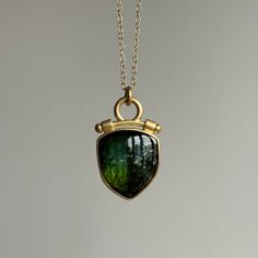 Remarkable in color and form, this lavish Namibian tourmaline pendant features undulating waves of green and blue, iridescent inclusions, and a regally constructed bail. 18k yellow gold Tourmaline, 11.34ct, 17mm x 19mm (5/8" x 3/4")1.5mm cable chain is 18" long Bezel Jewelry, Tourmaline Pendant, Newport Ri, Cabochon Pendant, Green Tourmaline, Green And Blue, Cable Chain, Jewelry Ideas, Letterpress