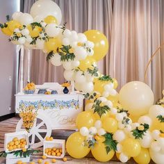 yellow and white balloons are on display at a wedding reception in front of a wagon