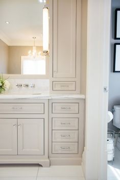 a bathroom with white cabinets and a large mirror