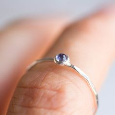 Tiny skinny stackable ring with beautiful Tanzanite stone. Its blue color with a shade of purple is fascinating.The ring is made with a skinny band, which allows you to create mind-blowing stacking sets! The ring is 0,8-0,9 mm thick and looks very dainty on the finger. Choose the cut of the stone (smooth or rose cut) and material for the ring (sterling silver or 9k gold).If you want to change the ring band design or get a custom ring or ring sets, feel free to contact me.You can order a ring of Sterling Silver Birthstone Ring For Everyday, Everyday Sterling Silver Birthstone Ring With Gemstone, Everyday Sterling Silver Solitaire Birthstone Ring, Dainty Adjustable Sapphire Ring In Sterling Silver, Everyday Sapphire Birthstone Ring With Round Band, Dainty Stackable Sapphire Ring, Everyday Sapphire Ring Birthstone Round Band, Sterling Silver Midi Rings With Birthstone, Tiny Adjustable Sterling Silver Birthstone Ring