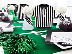 some black and white striped shirts are on display at a football themed party with pom poms