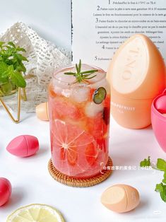 a glass filled with liquid next to some lemons and other items on a table