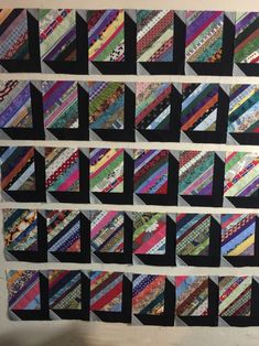 a wall hanging made up of strips of different colors and sizes on it's side