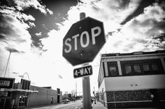 a black and white photo of a stop sign in the middle of an empty street