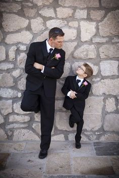 a man in a suit and tie standing next to a little boy wearing a tuxedo