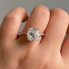 a woman's hand with a ring on it and a diamond in the middle