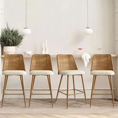 four wicker bar stools in front of a white wall