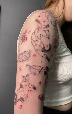 a woman's arm with cats and hearts all over it, on her left shoulder