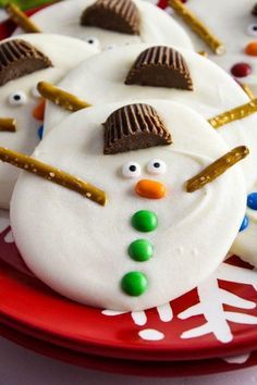 frosted snowman cookies are on a red plate