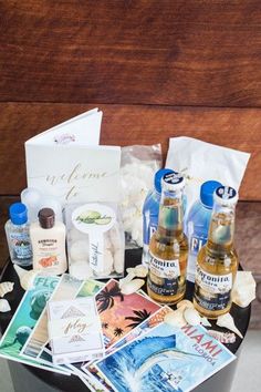 two bottles of alcohol sitting on top of a trash can filled with cards and other items