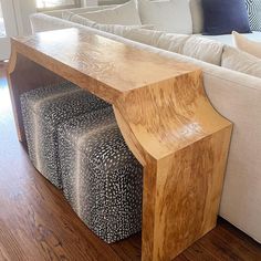 a wooden table sitting on top of a hard wood floor next to a white couch