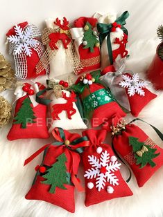 red and green christmas bells with snowflakes on them sitting next to pine cones