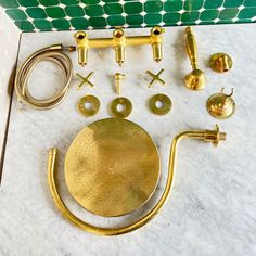 brass bathroom accessories laid out on a marble counter top