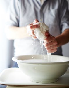 a man is washing his hands in a bowl