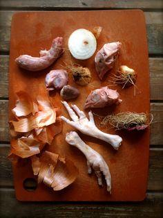 an overhead view of several different types of food on a cutting board, including onions and garlic