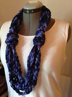 a woman wearing a purple scarf on top of a mannequin