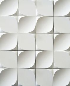 a white wall with many square shapes on it's sides and one in the middle