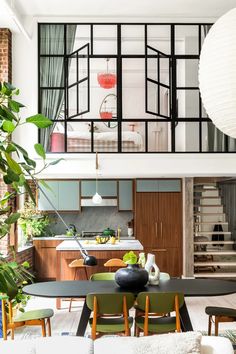 a living room filled with furniture next to a kitchen and dining room table in front of an open floor plan