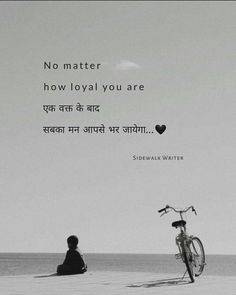 a person sitting on the beach next to a bike with a quote written in it