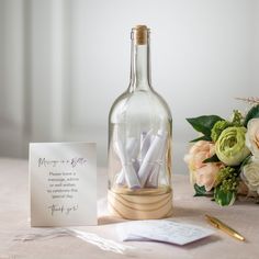 a message in a bottle next to some flowers