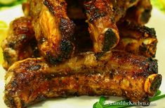 grilled chicken wings on a plate with lemon wedges and parsley in the background