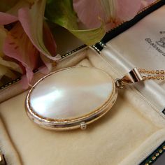 An exceptional vintage 9ct rolled gold locket with chain. This unique oval shaped locket has an eye catching mother of pearl plaque on front - the lustre and color of the shell panel is really special, we hope that the photos do it justice. This locket comes with a new gold filled gold chain making it ready to wear right away. This locket is perfect for storing a precious keepsake inside such as a photo or a lock of hair.  A unique true vintage & personal piece of jewellery! This Locket comes pr Antique Oval Pearl Pendant Jewelry, Elegant Oval Cameo Locket Necklace, Elegant Cameo Locket Necklace For Wedding, Shell Locket, Lock Of Hair, Marvel Gifts, Chain Making, Hair Locks, Gold Locket