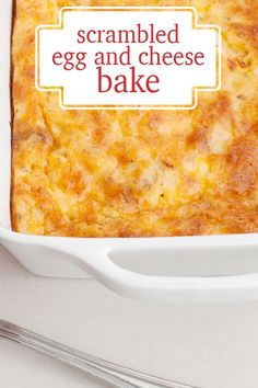 an egg and cheese bake in a white casserole dish with a spoon