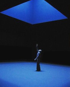 a person standing in the middle of a room with blue lights on it's ceiling