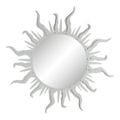 a white sun shaped mirror hanging on the wall