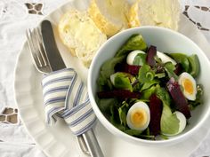 a white plate topped with salad and eggs