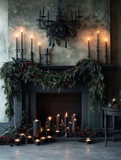 a fireplace decorated with candles and greenery