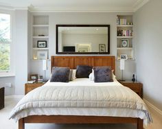 a bedroom with a large bed and lots of shelves